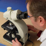 Designer using a microscope